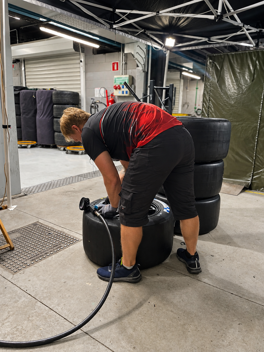 Técnico trabajando sobre un neumático de competición durante la noche.